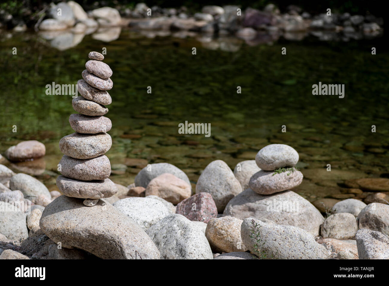 Ausgewogene Steine in der Nähe eines Flusses mit großen Kopie Platz auf der rechten Seite des Bildes stack, Zen Meditation Wellness Entspannung Hintergrund Stockfoto