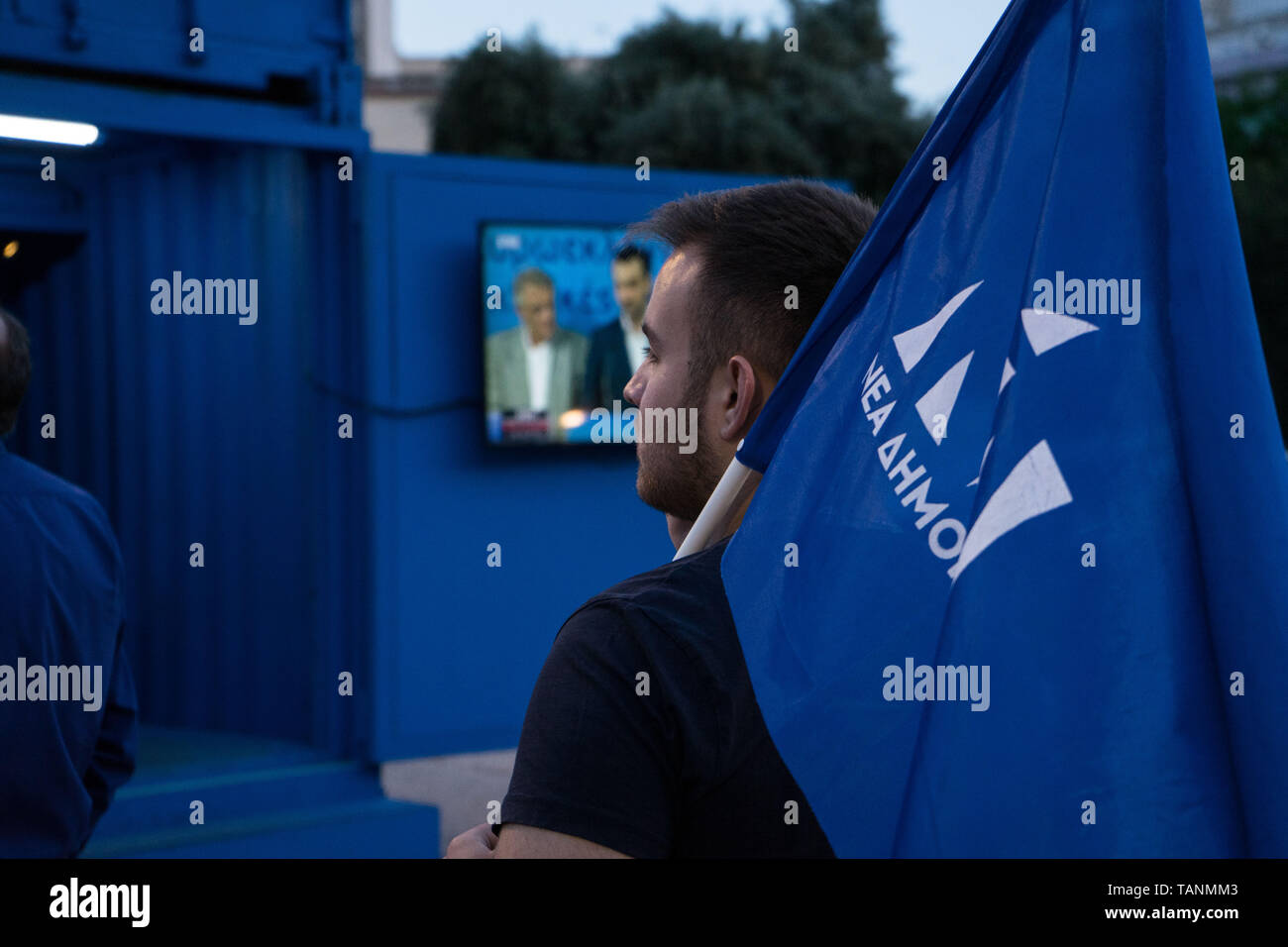 Ein Unterstützer der Rechten griechischen politischen Partei "Neue Demokratie" gesehen, die eine Flagge, während Sie die exit polls des Europäischen Parlaments wahl Wahlen Neue Demokratie Kiosk in Athen. Die Wahlen zum Europäischen Parlament fand zwischen 23. und 26. Mai 2019 mit der Teilnahme aller Länder Mitglieder der Europäischen Union und die Neunte parlamentarische Wahlen seit 1979. Stockfoto