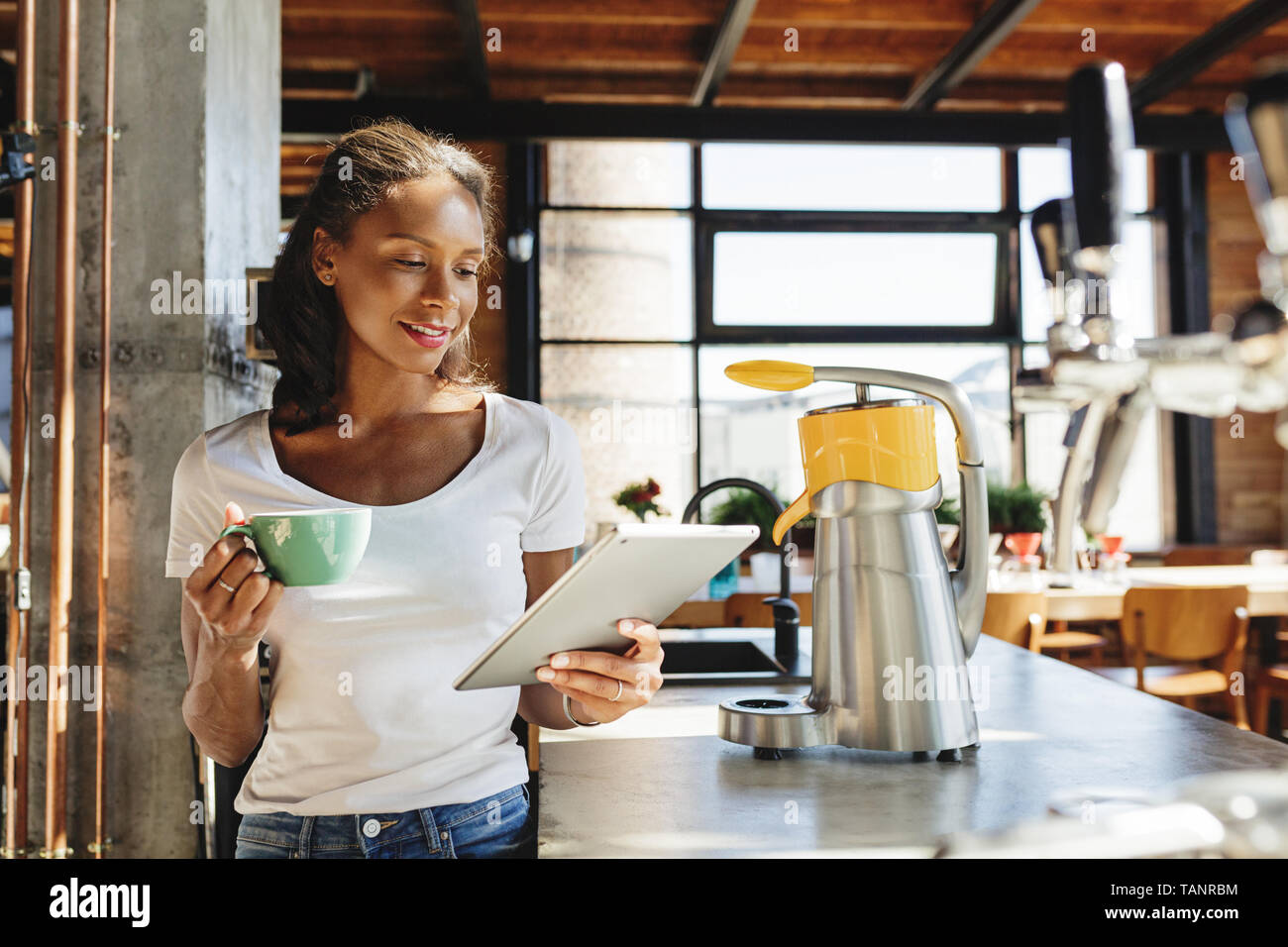Junge Unternehmer stehen an der Theke an. Frau liest aus digitalen Tablet in Ihrem Cafe am Morgen. Stockfoto