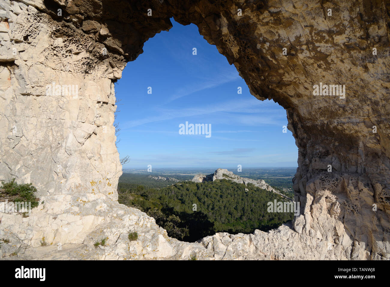 Blick auf die Alpilles Hügeln umrahmt von einem Felsen Loch in Le Rocher des Deux Trous, Les Alpilles Regional Park, Saint-Rémy-de-Provence Provence Frankreich Stockfoto