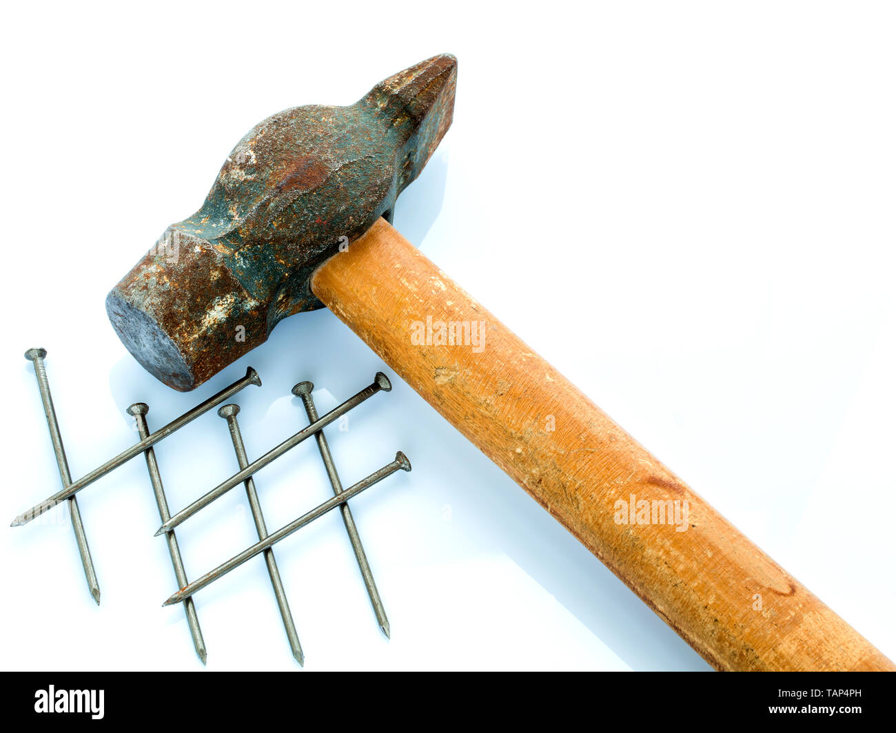 Eine alte Hammer mit einem hölzernen Handgriff und ein paar Nägel. Objekte auf einem hellen Hintergrund Stockfoto