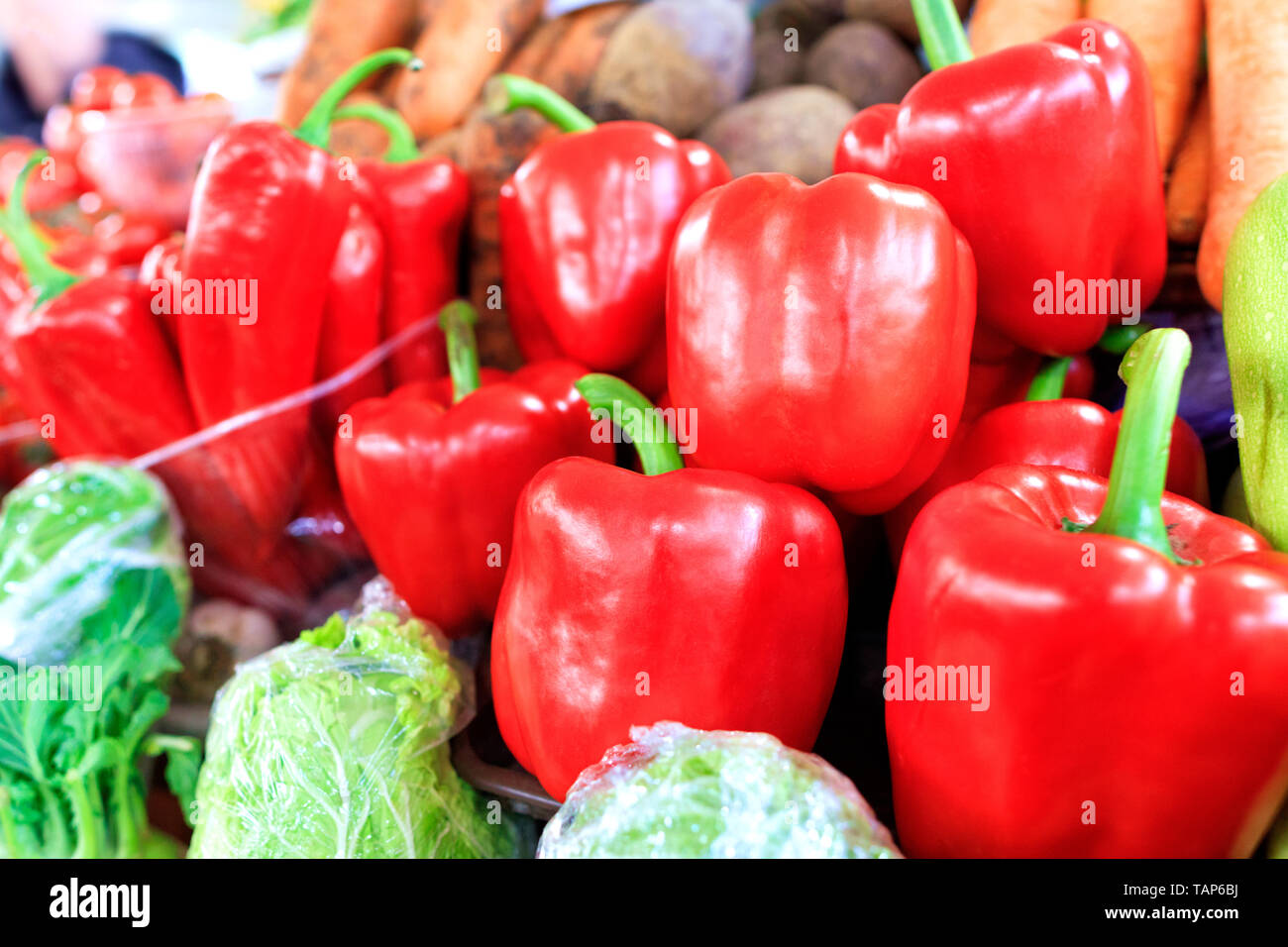 Große Reifen roten süßen Paprika close-up auf dem Hintergrund von anderen Gemüse werden in Schalen auf dem Markt bei Tageslicht verkauft. Stockfoto
