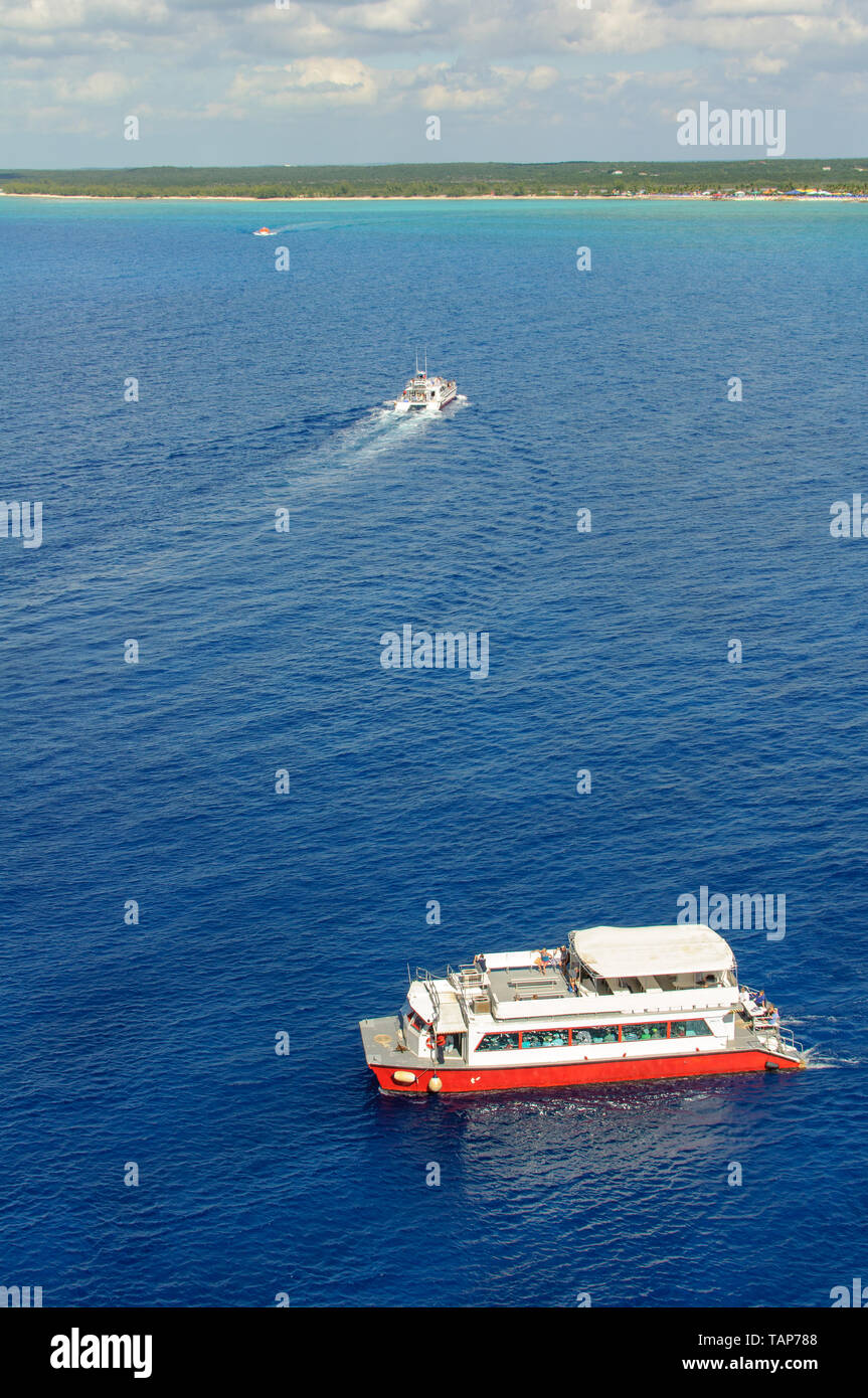 Drei rote und weiße Meer Boote Passagiere, die von der Folie zum Ufer. Bewölkter Himmel, grünen, tropischen Insel und das blaue Meer. Luftaufnahme Stockfoto