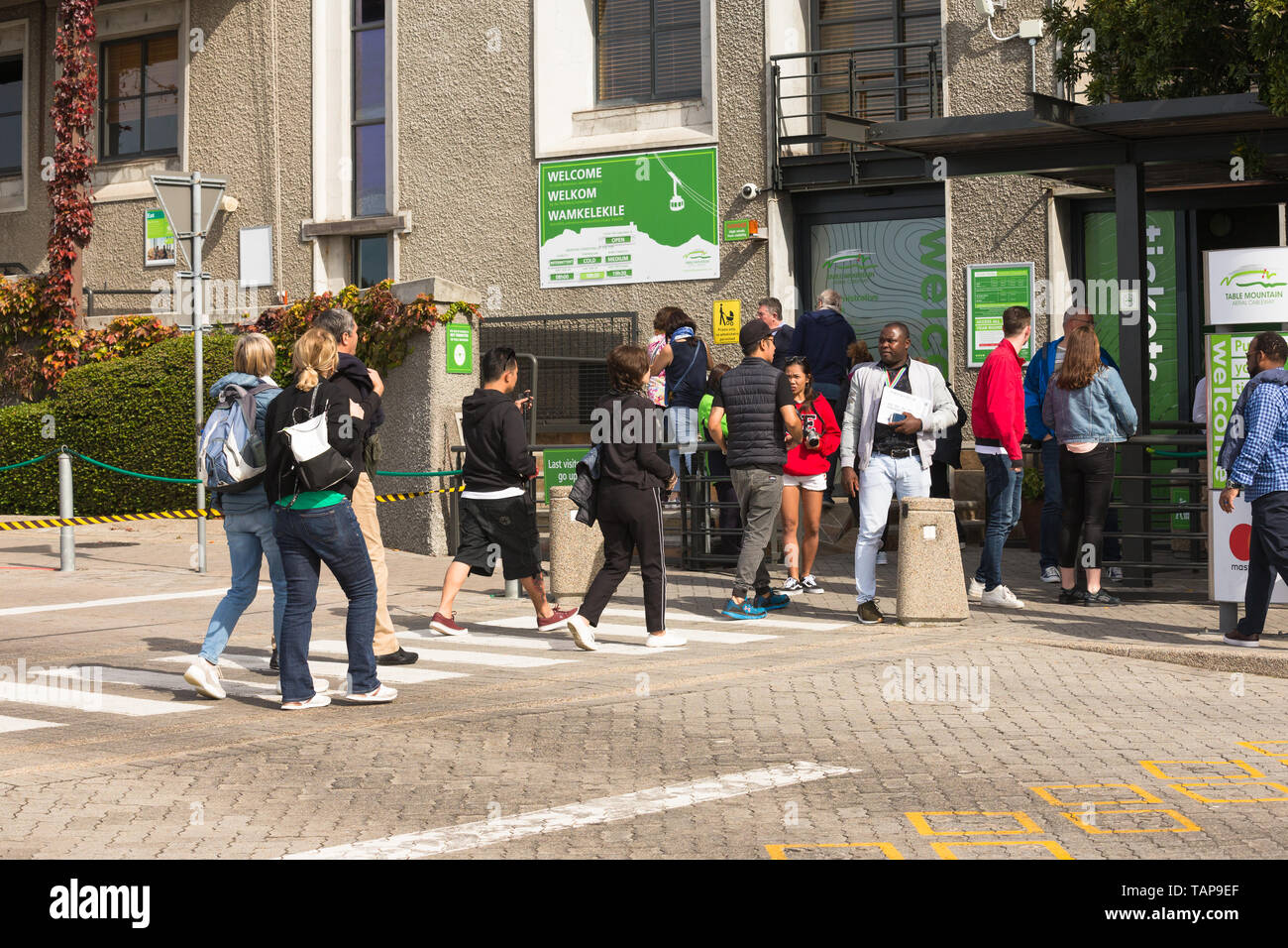 Menschen und Touristen Kreuzung an einem Zebrastreifen zum Ticket Office am Tafelberg unteren Seilbahnstation Tickets in Kapstadt zu kaufen Stockfoto