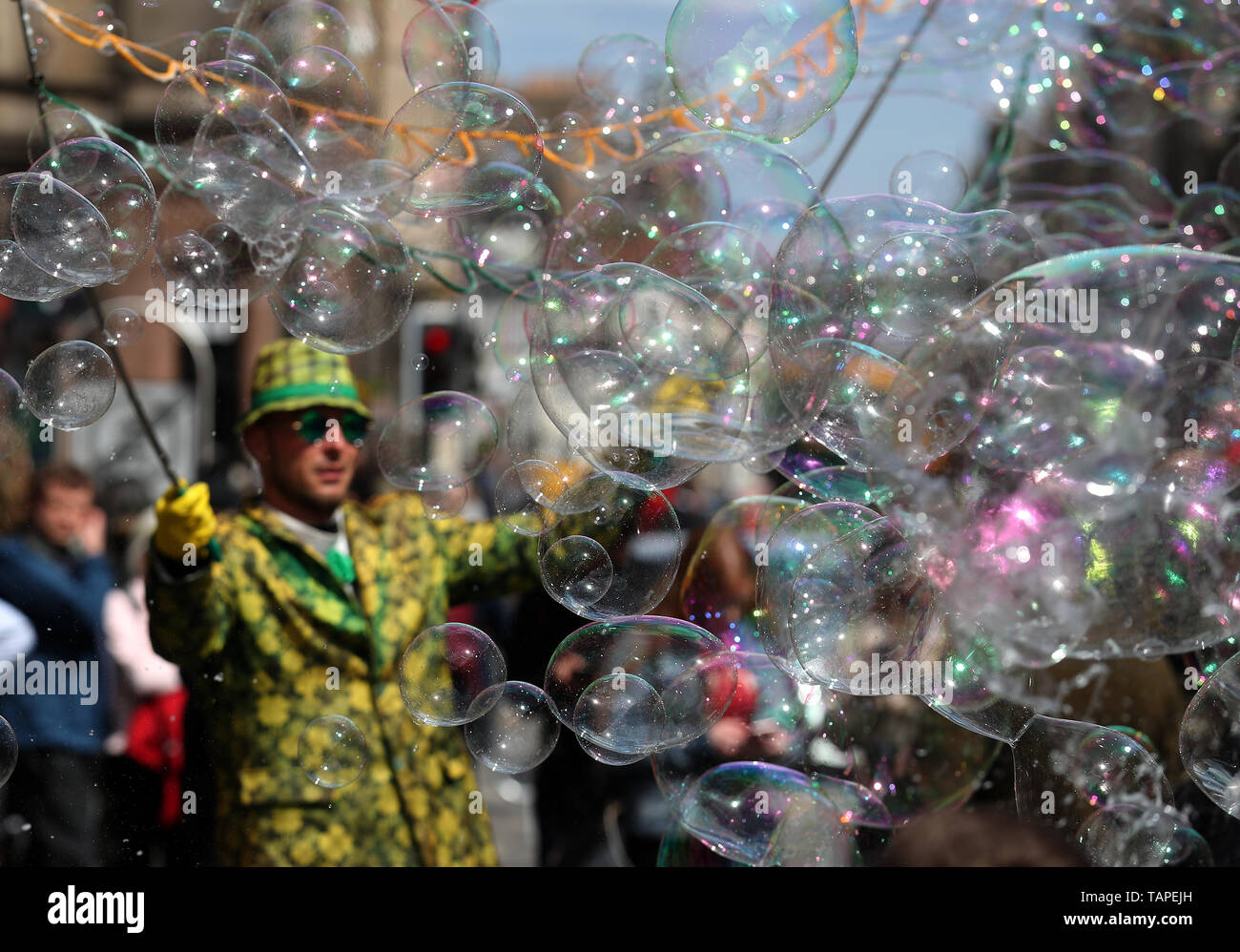 Kinder versuchen, Blasen von einer Straße Interpret auf Feiertag Montag zu verfangen, entlang der der Royal Mile in Edinburgh. Stockfoto