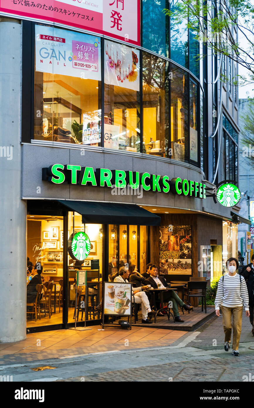 Kumamoto. Nachtleben und Shopping Arkade. Menschen innerhalb und außerhalb von Starbucks Coffee Shop sitzen. Abend mit Gebäude beleuchtet. Stockfoto