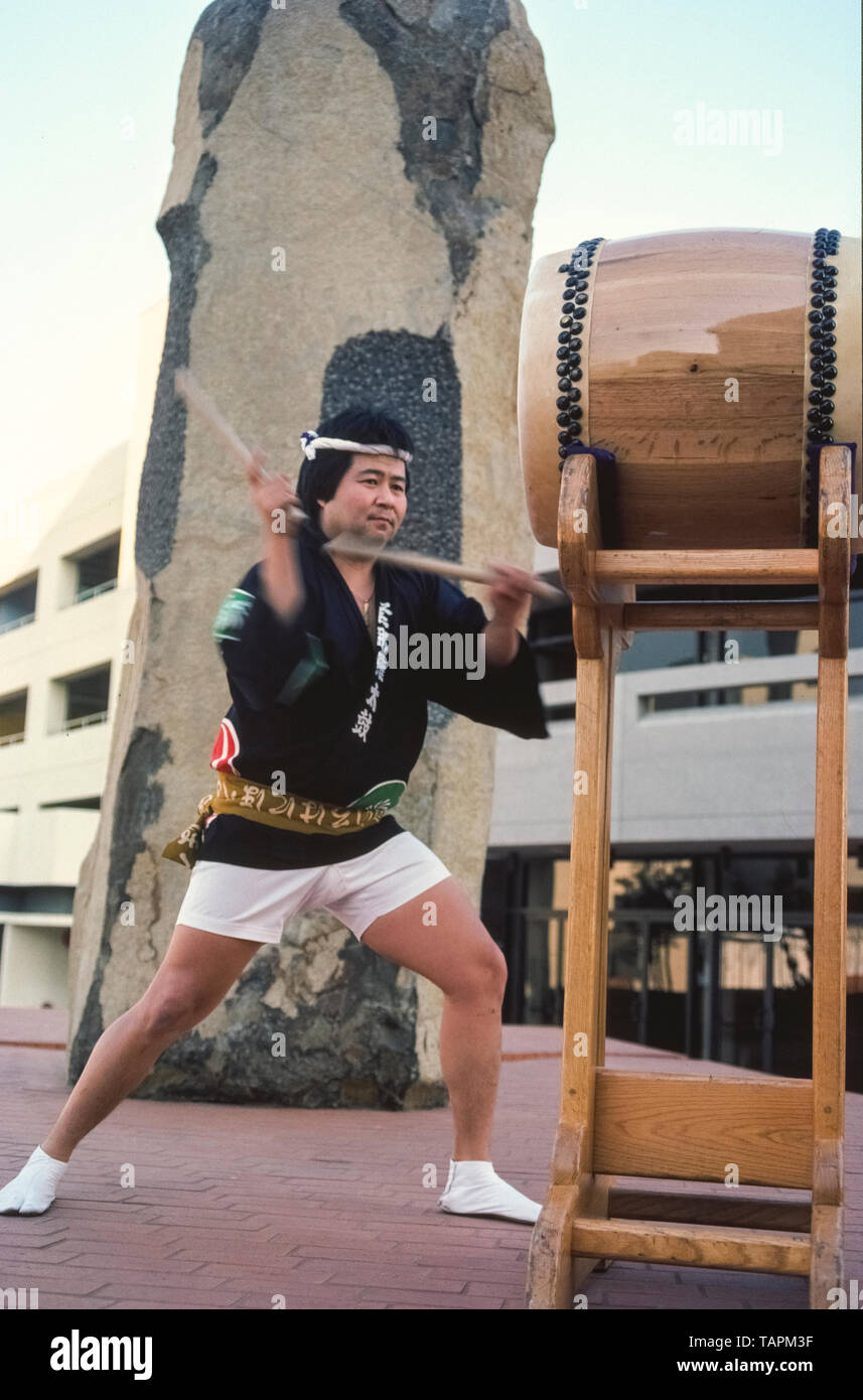 Ein Japaner führt Taiko Trommeln in Little Tokyo, dem historischen Herzen der japanischen amerikanischen Gemeinschaft in der Innenstadt von Los Angeles, Kalifornien, USA. Taiko Drum spielen laut, hart und schnell, und beinhaltet choreographierten Bewegungen, die viele mit japanischen Kampfsportarten der Schlagzeuger im Freien zu erkennen ist die japanisch-amerikanische Kultur- & Community Center (JACCC) Plaza mit monumentalen Basalt Skulpturen von weltweit renommierten artist Isamu Noguchi. Mit dem Titel "Der issei", Noguchi geformt sein Kunstwerk im Jahre 1980 als eine Hommage an die erste Generation der Japaner, die nach Amerika eingewandert Stockfoto