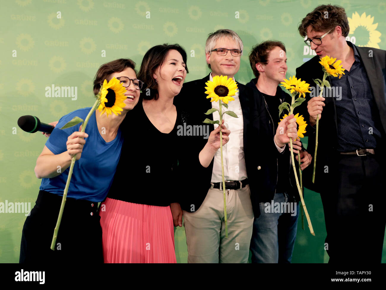 Berlin, Deutschland. 26 Mai, 2019. Hannah Neumann (L-R), Europäische Wahlkandidaten, Annalena Baerbock, Vorsitzende der Grünen, Sven Giegold, Mitglied des Europäischen Parlaments für die Grünen, Europäischen Wahlkandidaten Erik Marquardt und Michael Kellner, Direktor des Grüns, jubeln mit Sonnenblumen nach der Bekanntgabe der ersten Prognose für die Europawahlen. Credit: Kay Nietfeld/dpa/Alamy leben Nachrichten Stockfoto