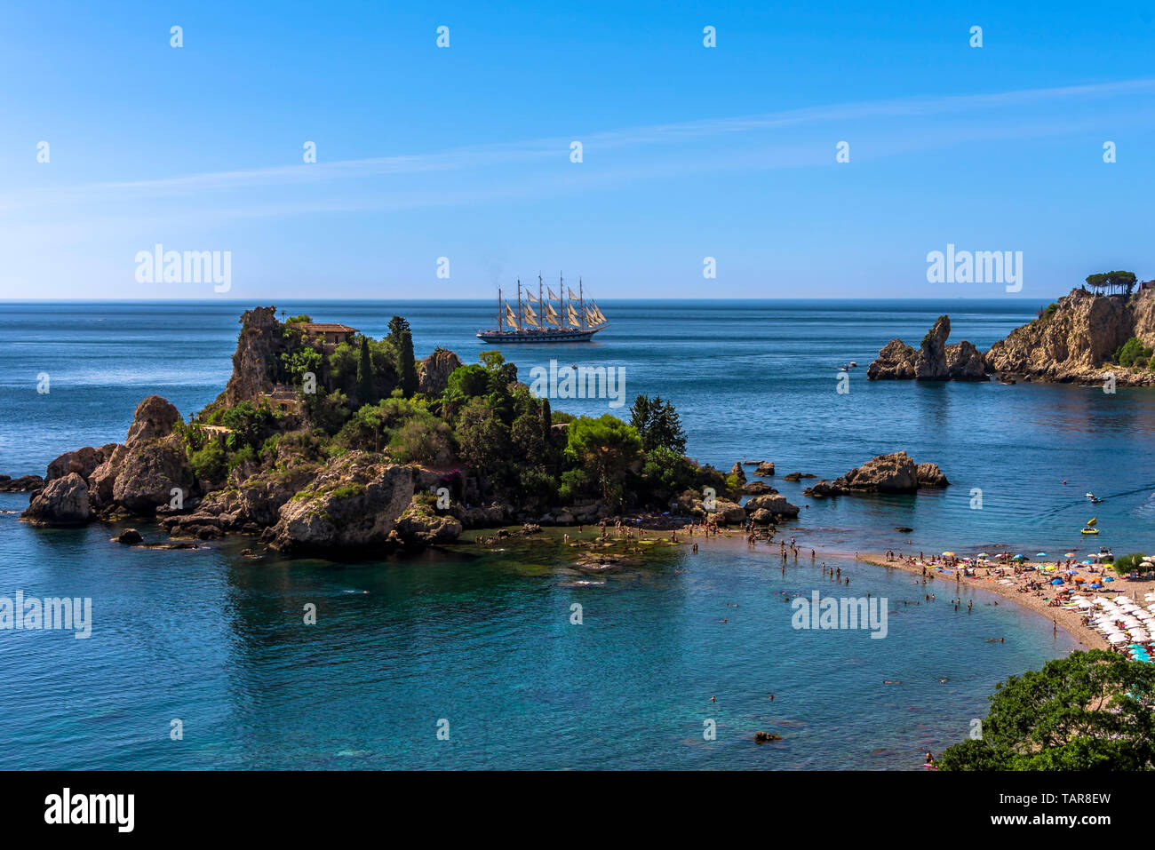 Die Menschen genießen die Sonne und das kristallklare Wasser am besten Strand in Sizilien - Isola Bella, Taormina. Stockfoto