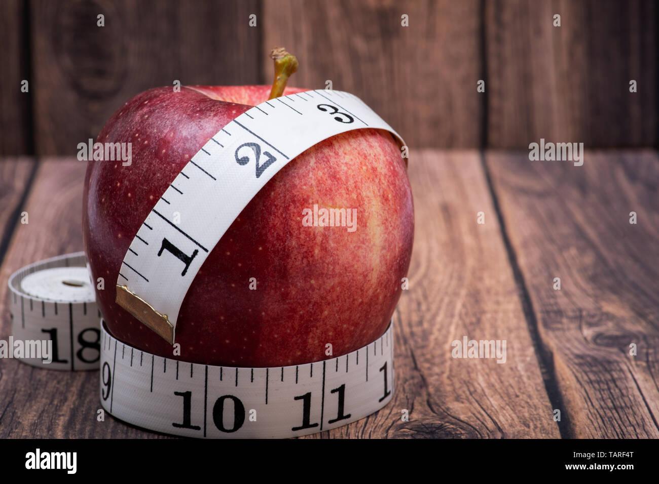 Red Apple und weiches Vinyl Maßband auf Holz- Hintergrund. Stockfoto
