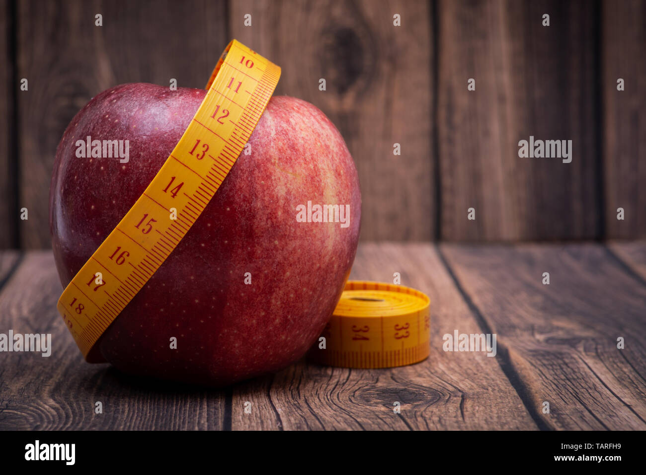 Red Apple und weiches Vinyl Maßband auf Holz- Hintergrund. Stockfoto
