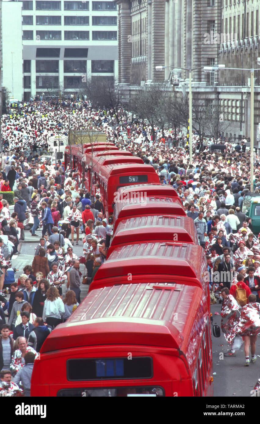 Auf roten Londoner single Doppeldeckerbusse bei der Masse der Leute in Folie decke Mars Marathonläufer sammeln Kleidung von Bus 1980s England Großbritannien Stockfoto