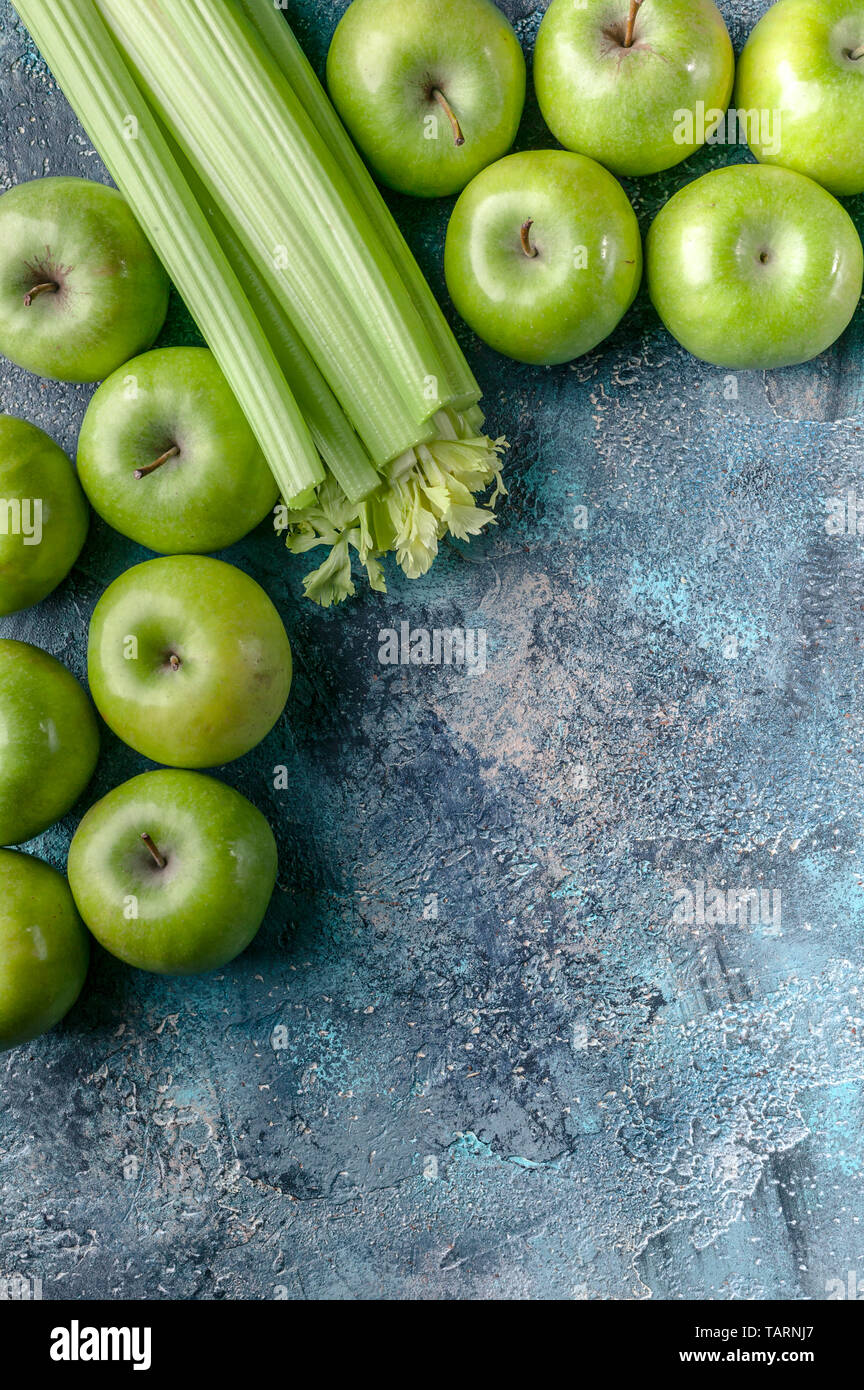 Grüne Äpfel und Sellerie auf einem blauen konkreten Hintergrund. Detox Programm, Diät, Gewichtsverlust. Flach Zusammensetzung Stockfoto