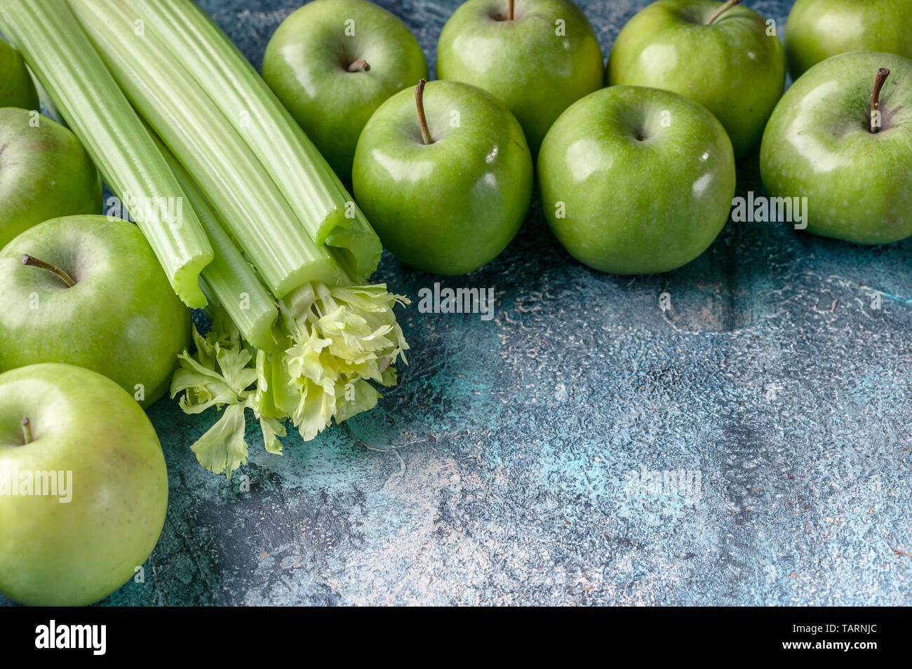 Grüne Äpfel und Sellerie auf einem blauen konkreten Hintergrund. Detox Programm, Diät, Gewichtsverlust. Horizontale flach Zusammensetzung Stockfoto