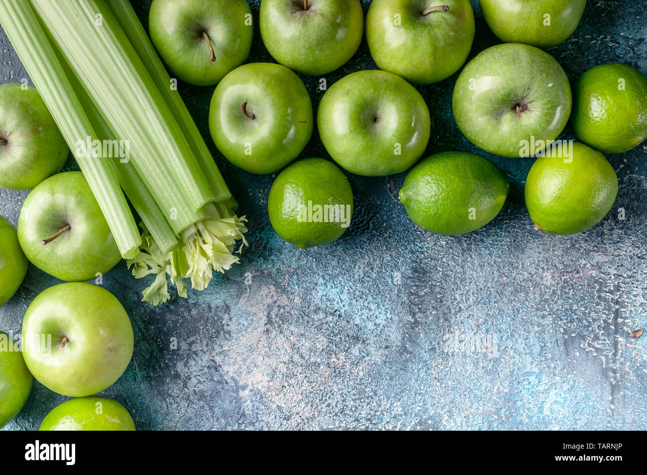Grüne Äpfel, Sellerie und Limetten auf einen konkreten Hintergrund. Detox Programm, Diät, Gewichtsverlust. Flach Komposition. Ansicht von oben Stockfoto