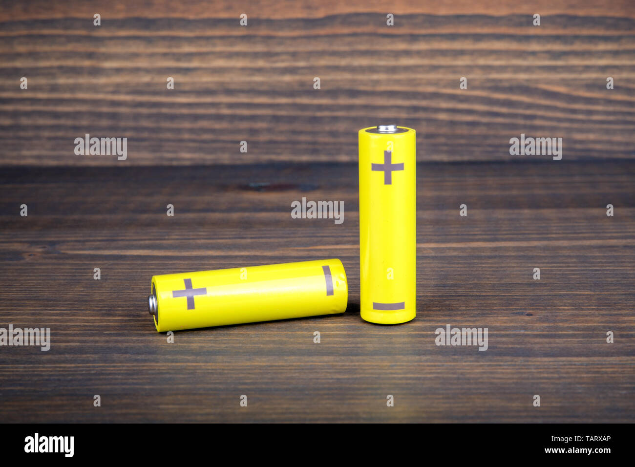 Batterien der Größe AA auf hölzernen Hintergrund Stockfoto