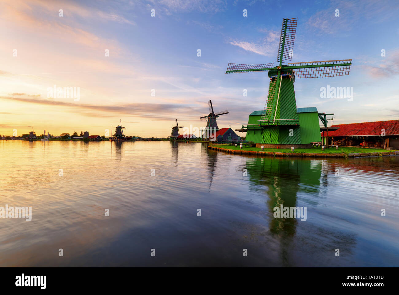 Holländische Landschaft mit Windmühle bei dramatischen Sonnenuntergang, Zaandam, Amsterdam, Niederlande Stockfoto