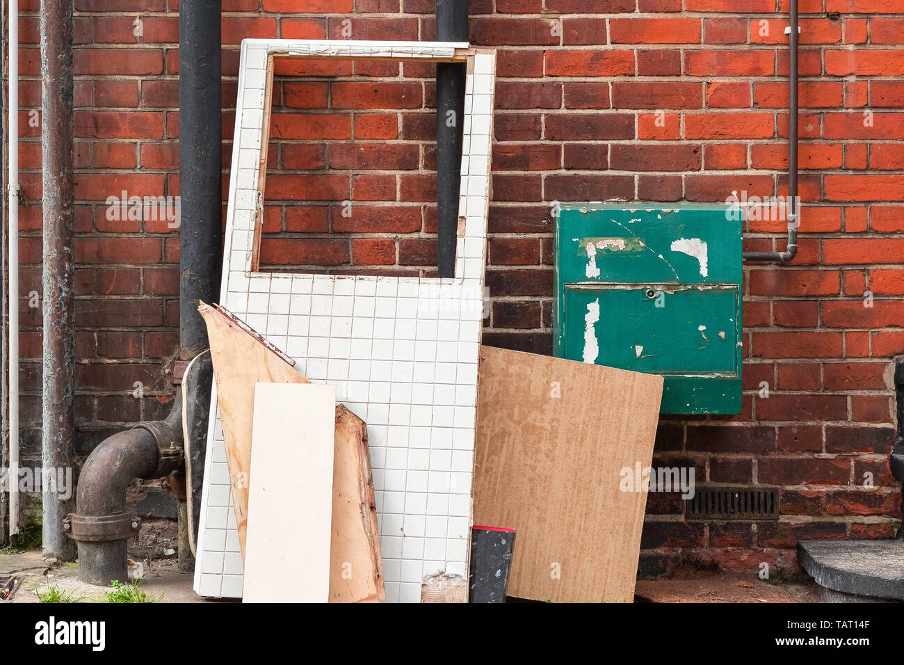 Große Platten und Abfälle Reihen links gegen eine Mauer, an der Ecke der London Street. Stockfoto