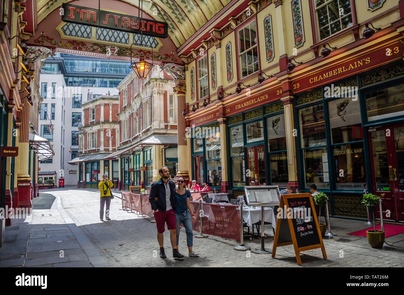 Ein paar schlendern Sie durch Leadenhall Market, einem reich verzierten, 14. Jahrhundert Markt im Finanzviertel der Stadt London, UK abgedeckt Stockfoto