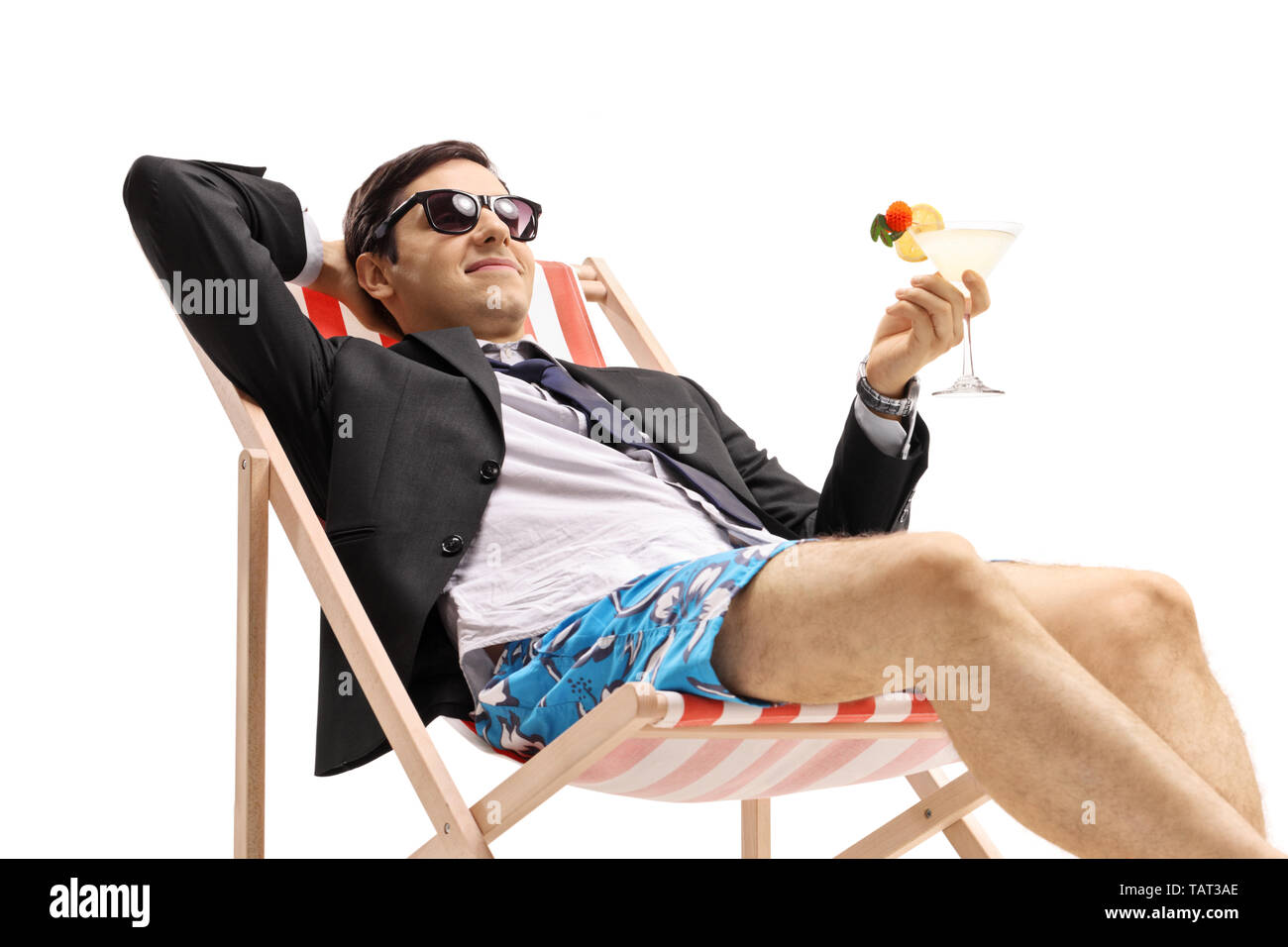Geschäftsmann mit einem Cocktail im Liegestuhl auf weißem Hintergrund liegend Stockfoto
