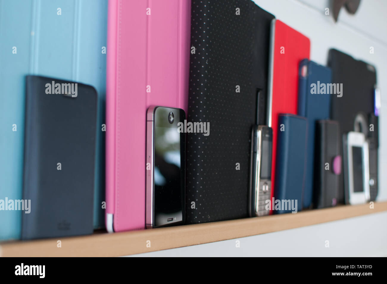 Eine Reihe von Apple iPads und Telefone auf einem Regal. Stockfoto