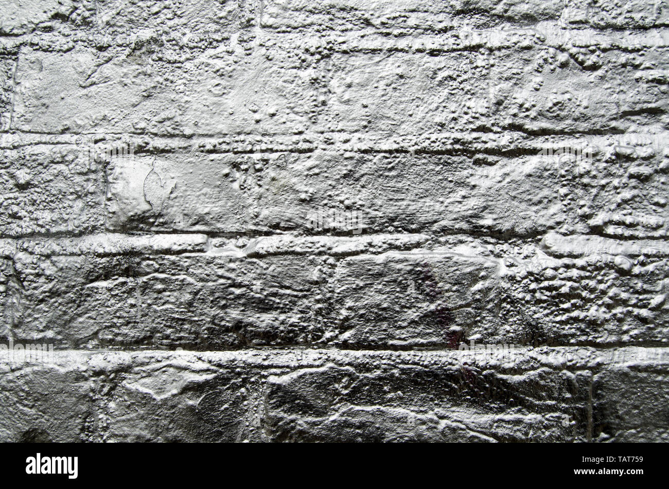 Eine Mauer gesprüht mit silberner Farbe. Stockfoto