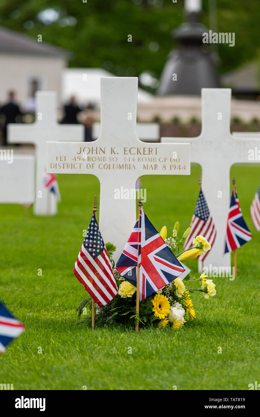 Kreuz Grabstein von Johannes K Eckert uns Memorial Tag der Erinnerung Veranstaltung in Cambridge amerikanischen Friedhof und Denkmal, Cambridgeshire, Großbritannien. Blumen und Fahnen Stockfoto