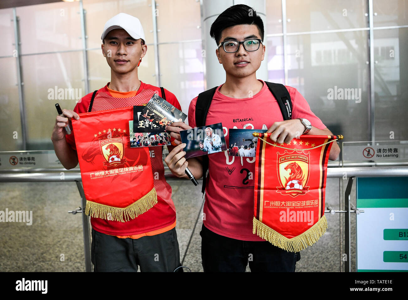 Chinesische Fans halten Banner Unterstützung von Marcello Lippi Zurück zur zweiten Stint als Cheftrainer der chinesischen Nationalmannschaft an der Guangzhou Baiyun International Airport in der Stadt Guangzhou, Provinz Guangdong im Süden Chinas, 28. Mai 2019 zu zeigen. Stockfoto