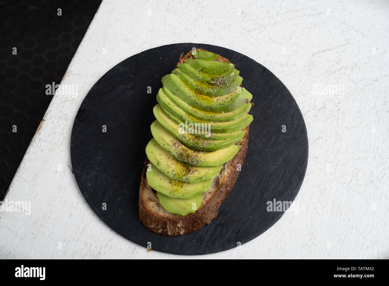 Avocado Toast auf schiefer kreisförmigen Bereich mit Stockfoto