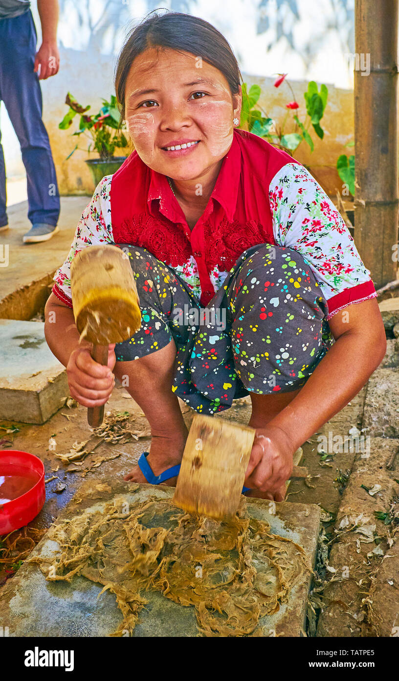 Nach PINDAYA, MYANMAR - Februar 19, 2018: Der Prozess der Shan Papier Produktion - die Handwerker schlägt das Papier Teig, der Maulbeerbaum, mit Holz- ma Stockfoto