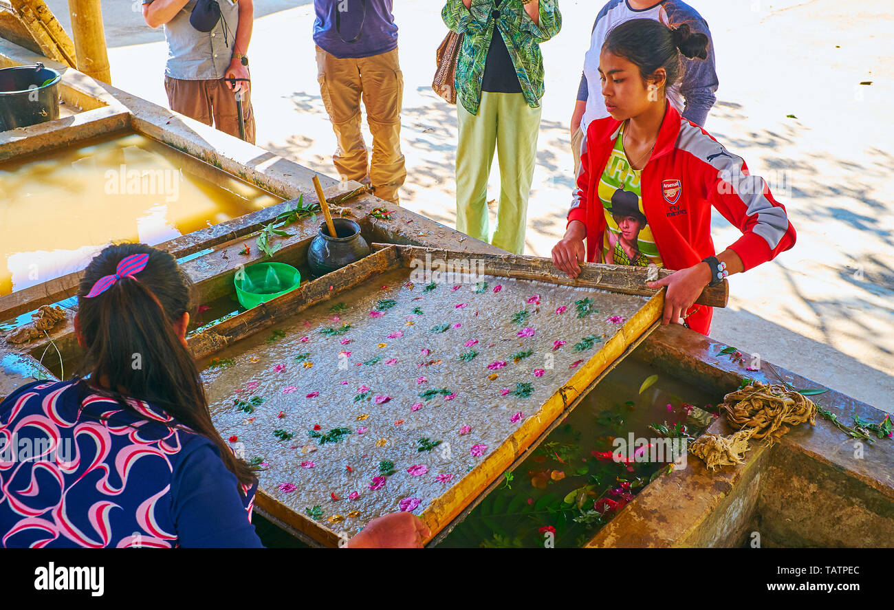 PINDAYA, MYANMAR - 19. FEBRUAR 2018: Die Handwerker durchführen Shan Papierherstellung, Sie ziehen Sie die Holzrahmen mit Zeile Papier aus dem Wasser Stockfoto
