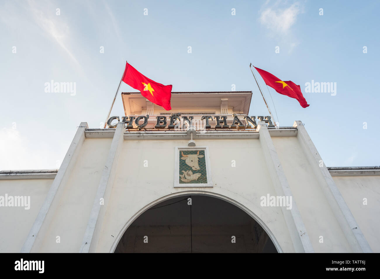 Ben Thanh Markt (1912-1914 erbaut), der Fassade und der Bogen des zentralen Eingang und zwei Schaukeln vietnamesischen Fahnen. Stockfoto