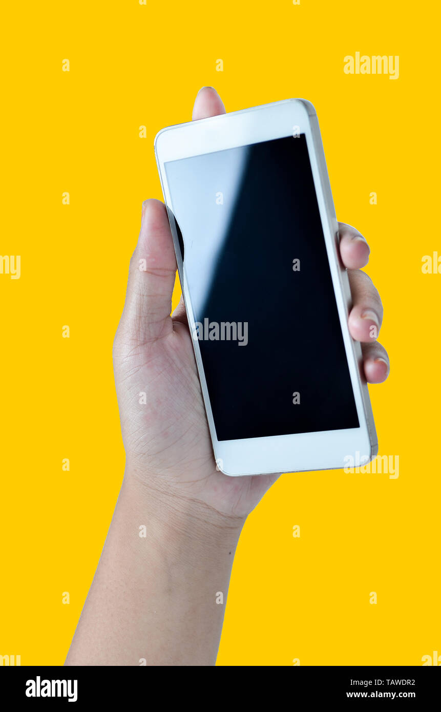 Famale Hände halten Sie das Telefon in den gelben Hintergrund isoliert Stockfoto