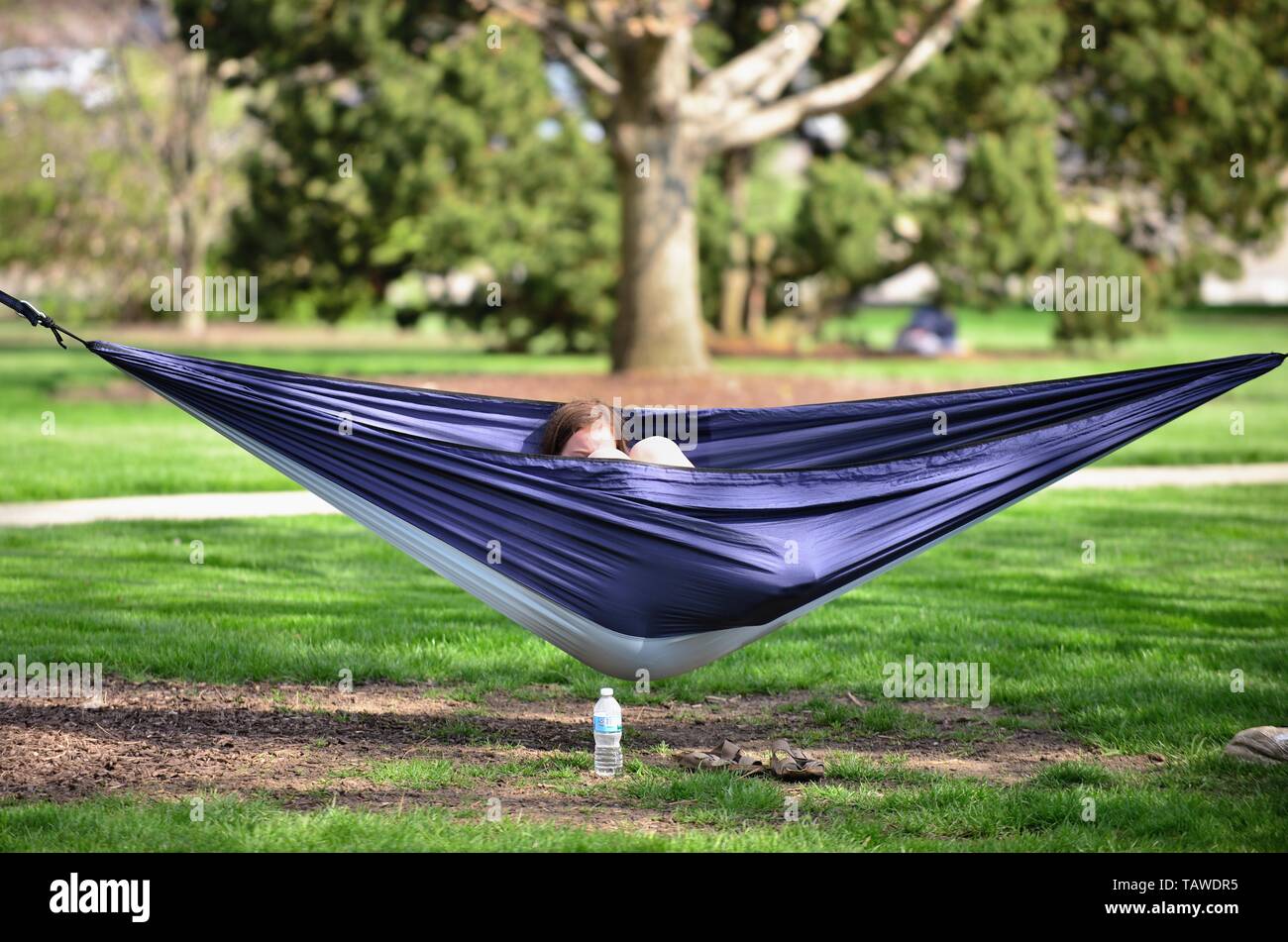 Wheaton, Illinois, USA. Eine Studentin entspannt in der Hängematte auf dem Campus der Wheaton College. Stockfoto