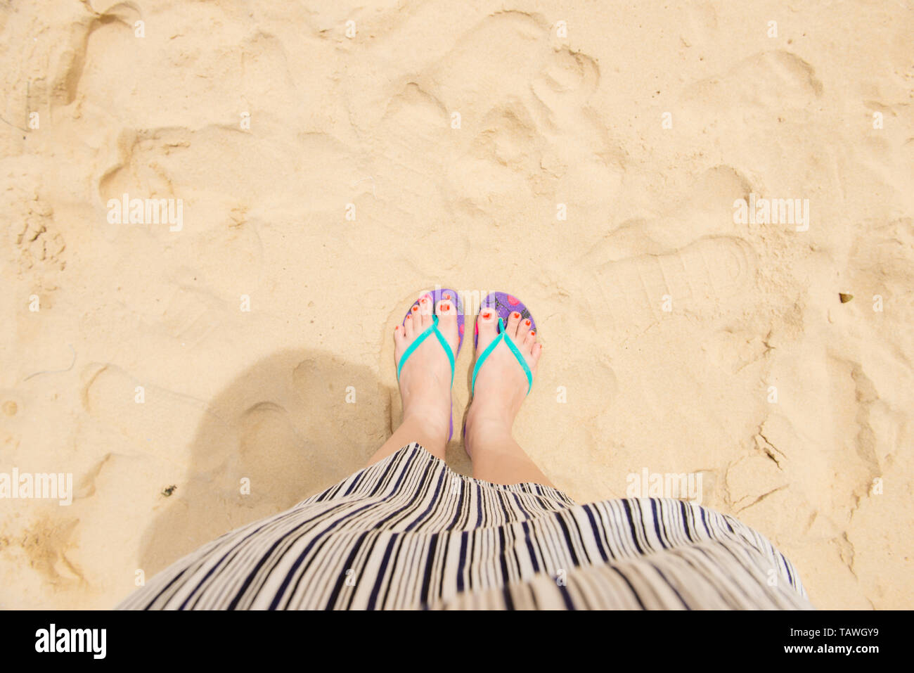 Weibliche Beine tragen Flip Flops in der Nähe von Meer Stockfoto