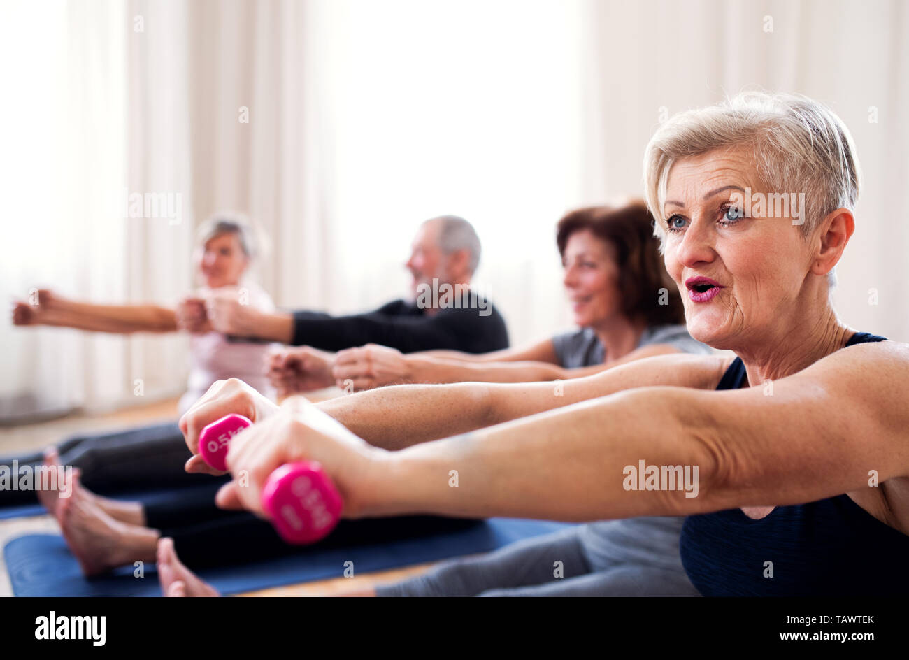 Gruppe von älteren Menschen, die Übung mit Hanteln in Community Center Club. Stockfoto
