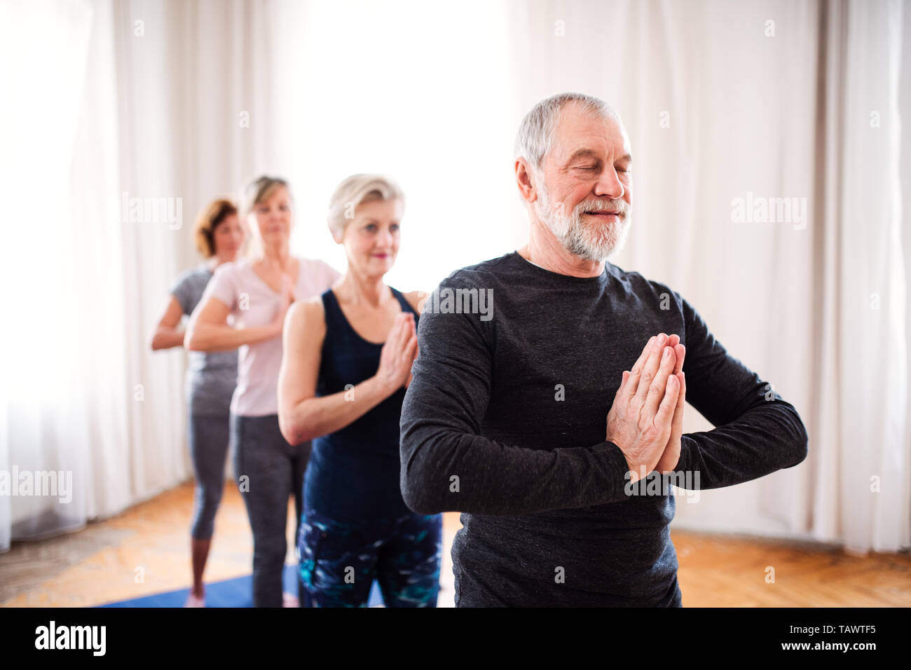 Gruppe von älteren Menschen, die Yoga Übung im Community Center Club. Stockfoto