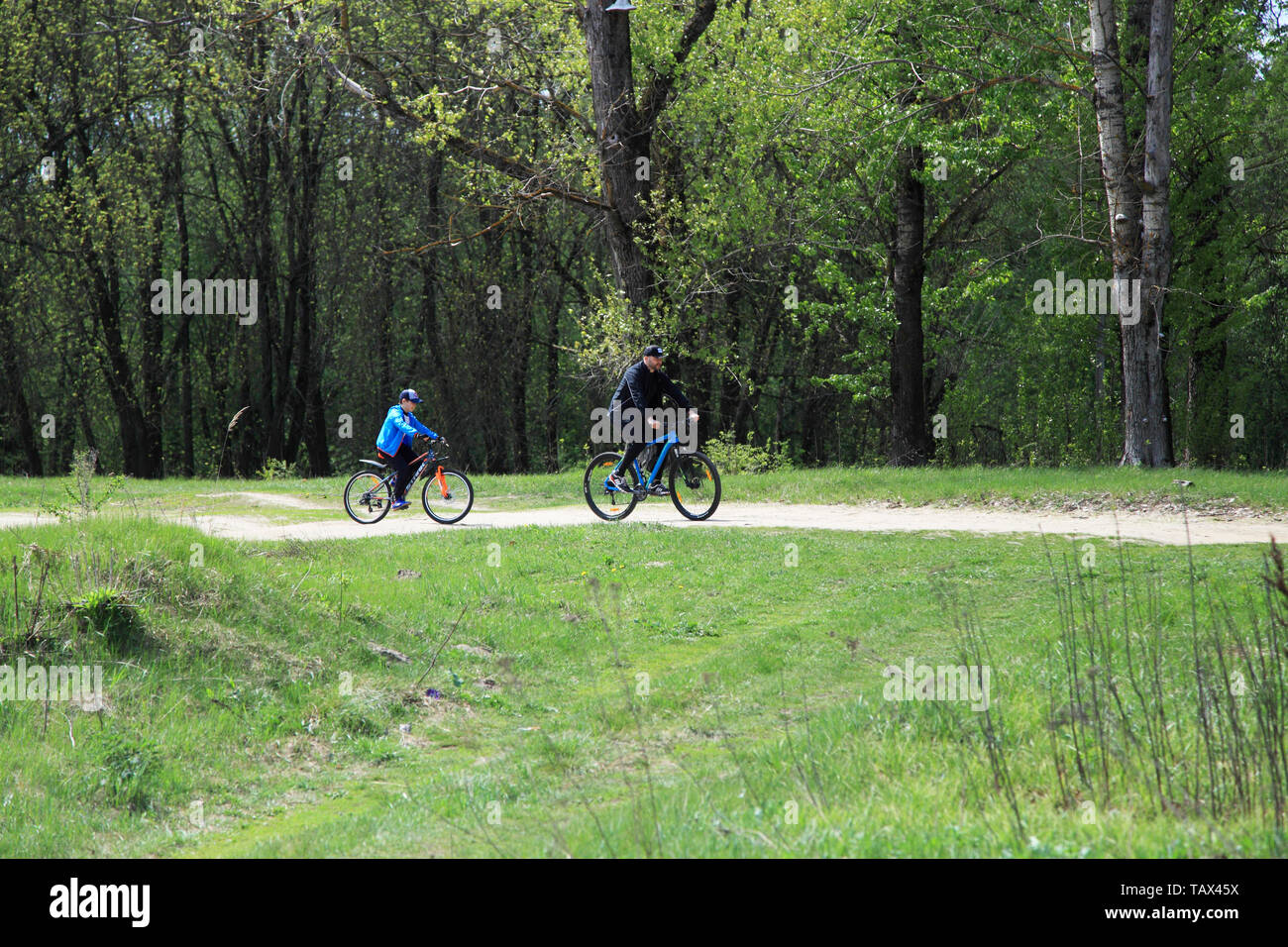 05 05 2019 Russland, Gebiet Brjansk. Ein Mann mit seinem Sohn auf dem Fahrrad im Park. Stockfoto