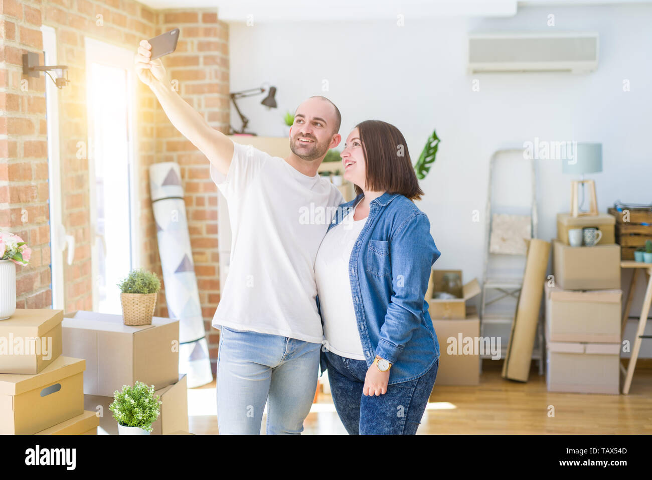 Junges Paar, ein Foto Foto mit Smartphone im neuen Zuhause und lächelt glücklich für Umzug in neue Wohnung Stockfoto