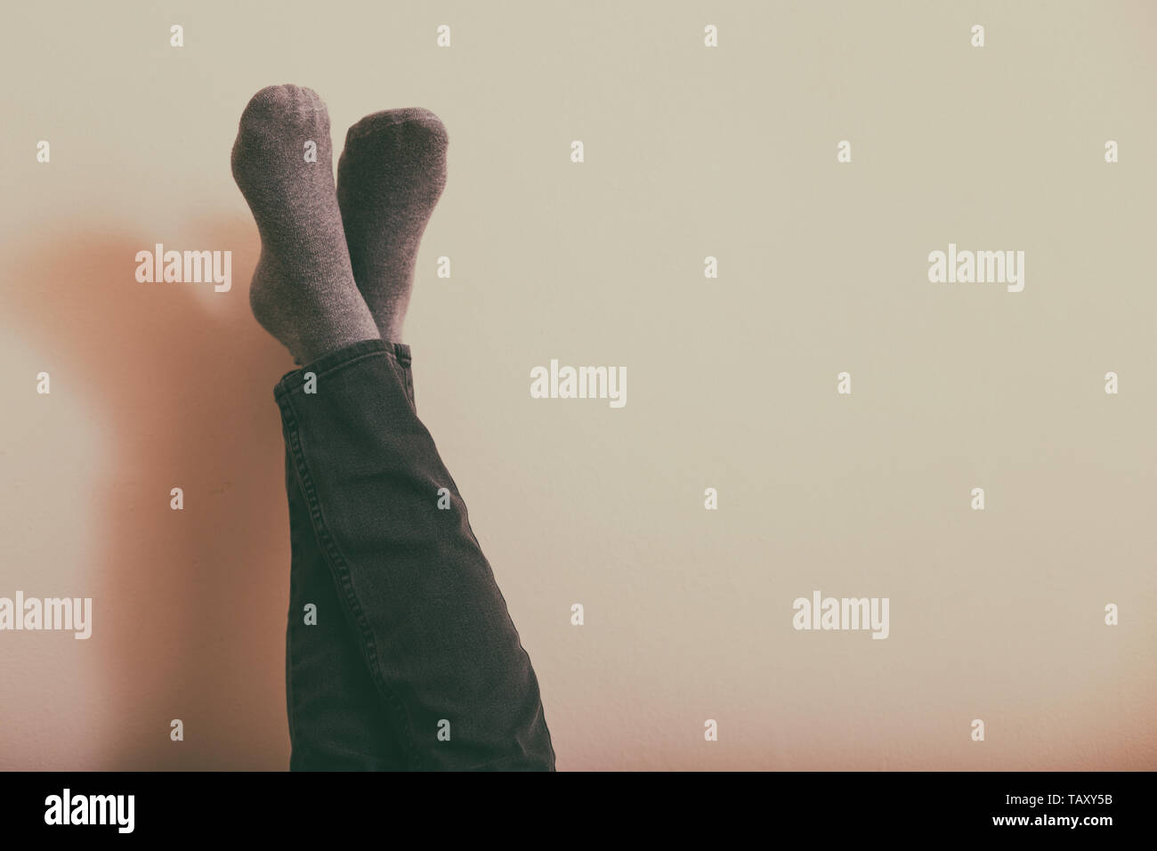 Frau mit Beine ausruhen vor der Wand. Getönten Foto. Stockfoto
