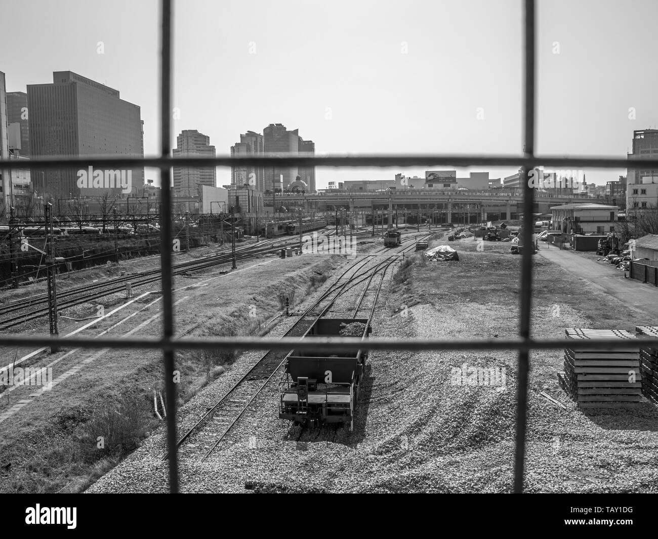 Seoul, Südkorea - März 2018: Foto von hinter einem Gitter, Blick auf den Bahnhof mit Schienen und Schotter genommen. Stadt ​​Background. Schwarz und Weiß. Stockfoto