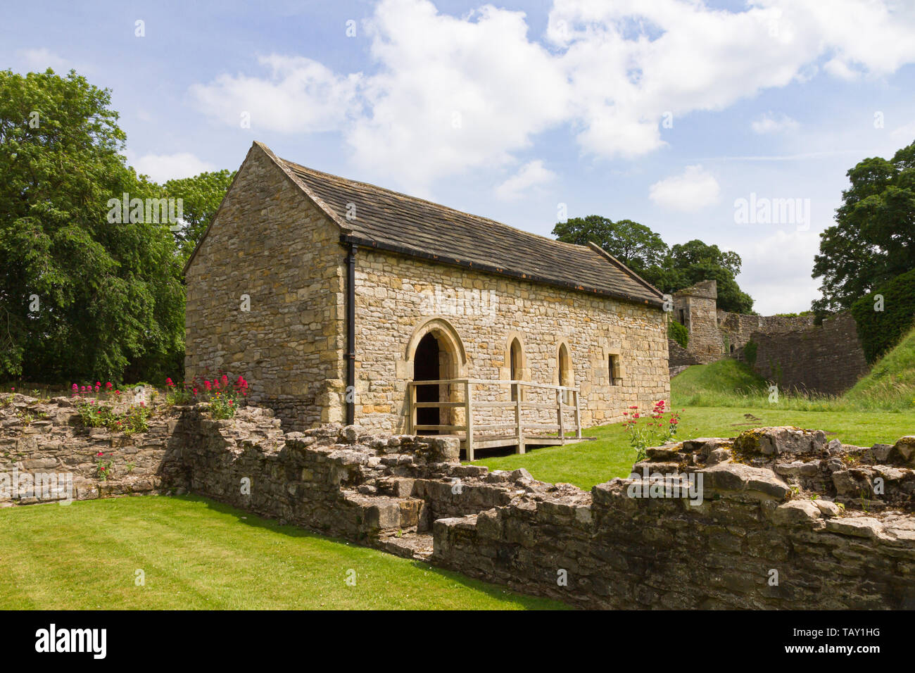 Pickering, North Yorkshire, Großbritannien: Restaurierte restaurierte gantry-kapelle steht neben zerstörten Wänden der Alten Halle in der vorburg von Pickering Castle. Stockfoto