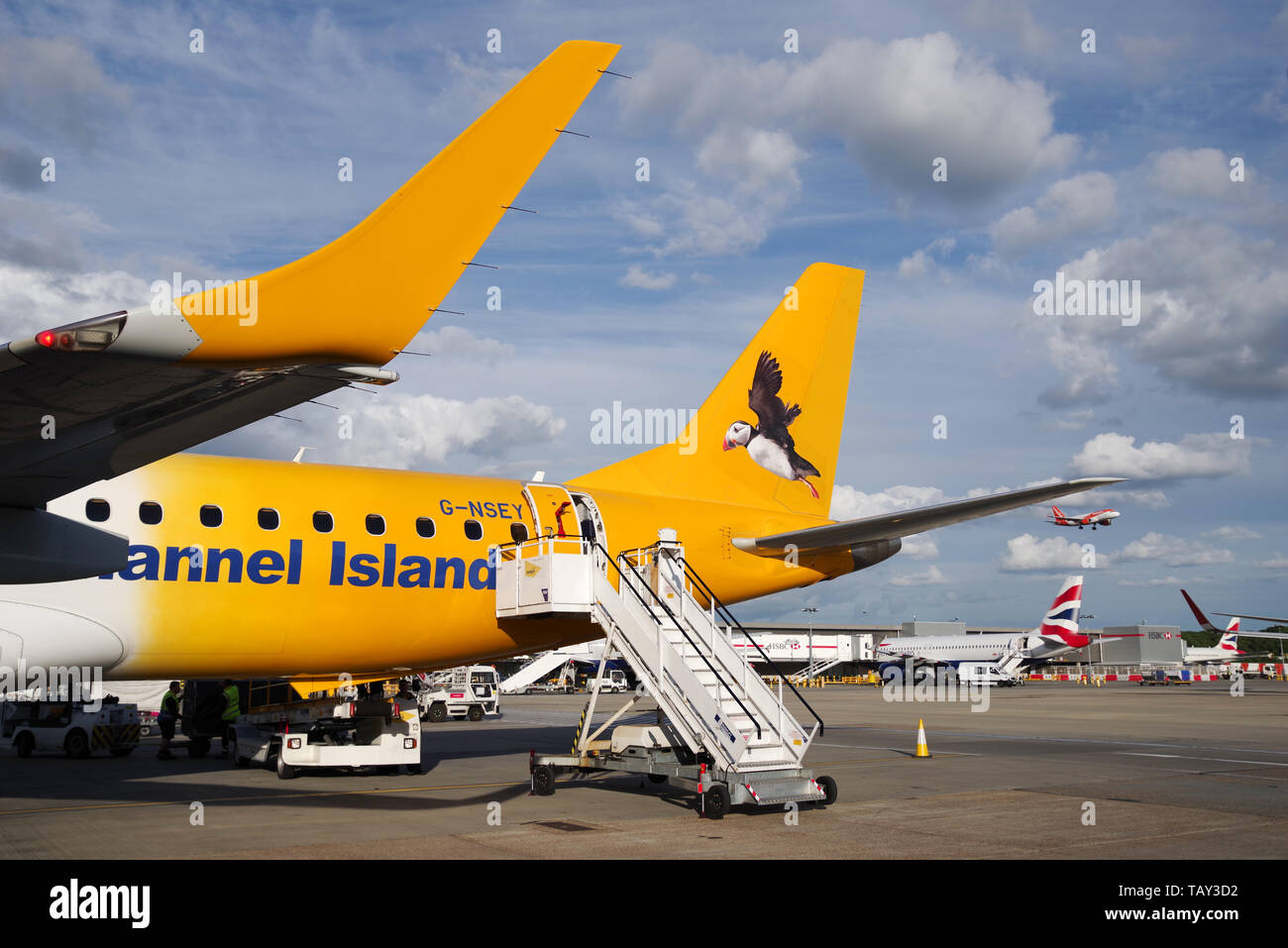 Aurigny airlines Embraer 195 mit einem fliegenden Papageitaucher auf seinem Schwanz am Flughafen London Gatwick geparkt lackiert Stockfoto