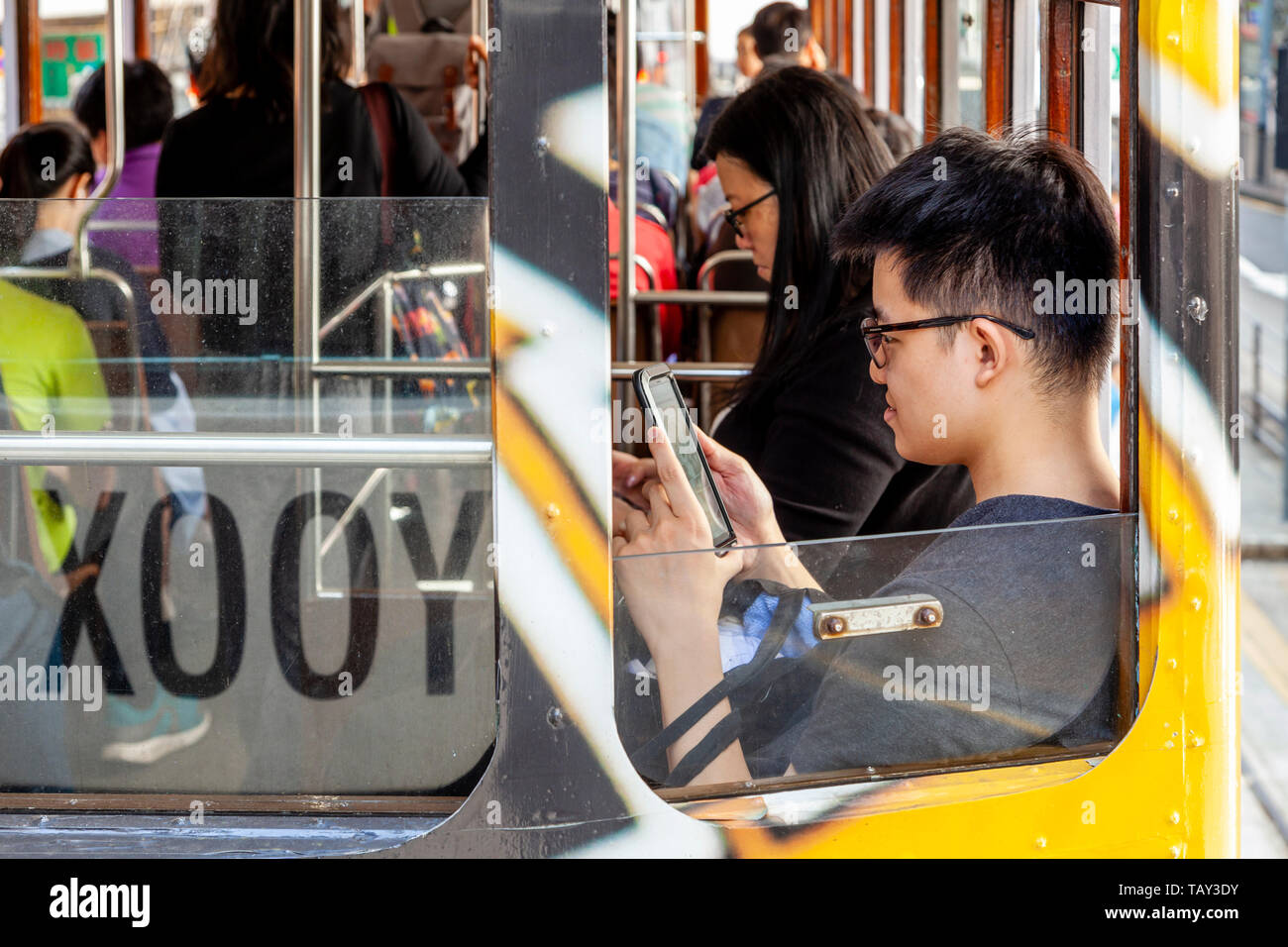 Die Passagiere an Bord eines traditionellen Hong Kong elektrische Straßenbahn, Hongkong, China Stockfoto