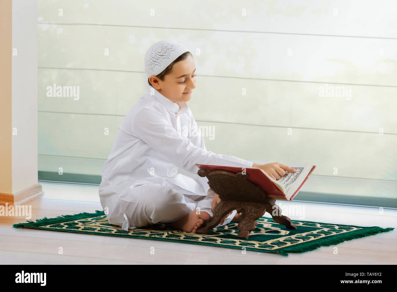Muslimische Junge liest den Koran Stockfoto