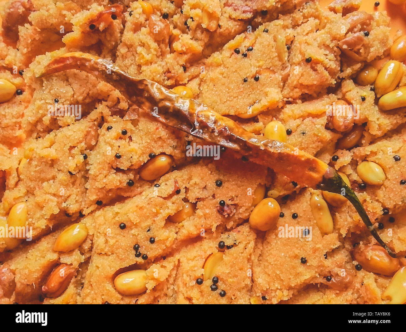 Nahaufnahme, Ansicht von oben leckere echte indische Snack food Rava Upama aus Grieß, Erdnuss und Gewürzen. Garniert mit gebratenen Red Hot Chili Pepper. Stockfoto