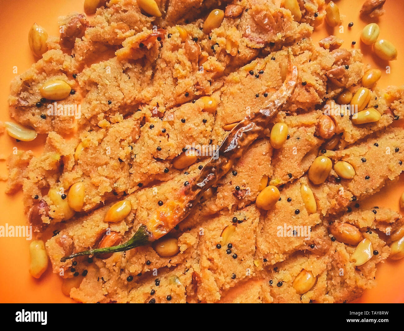 Nahaufnahme, Ansicht von oben leckere echte indische Snack food Rava Upama aus Grieß, Erdnuss und Gewürzen. Garniert mit gebratenen Red Hot Chili Pepper. Stockfoto