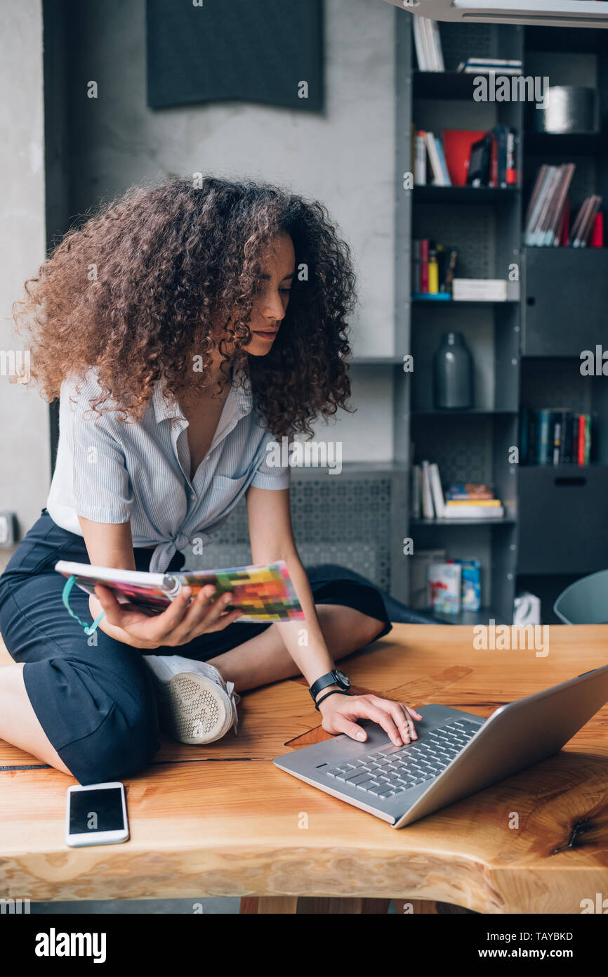 Junge kaukasier Frau mit Laptop im modernen Coworking office - Freiberufliche, Interaktion, Kommunikation Stockfoto