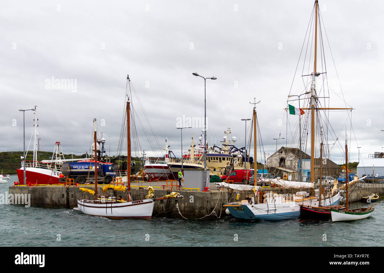 Traditionelle hölzerne Segelschiffe neben einem Pier mit modernen Trawler im Hintergrund. Stockfoto
