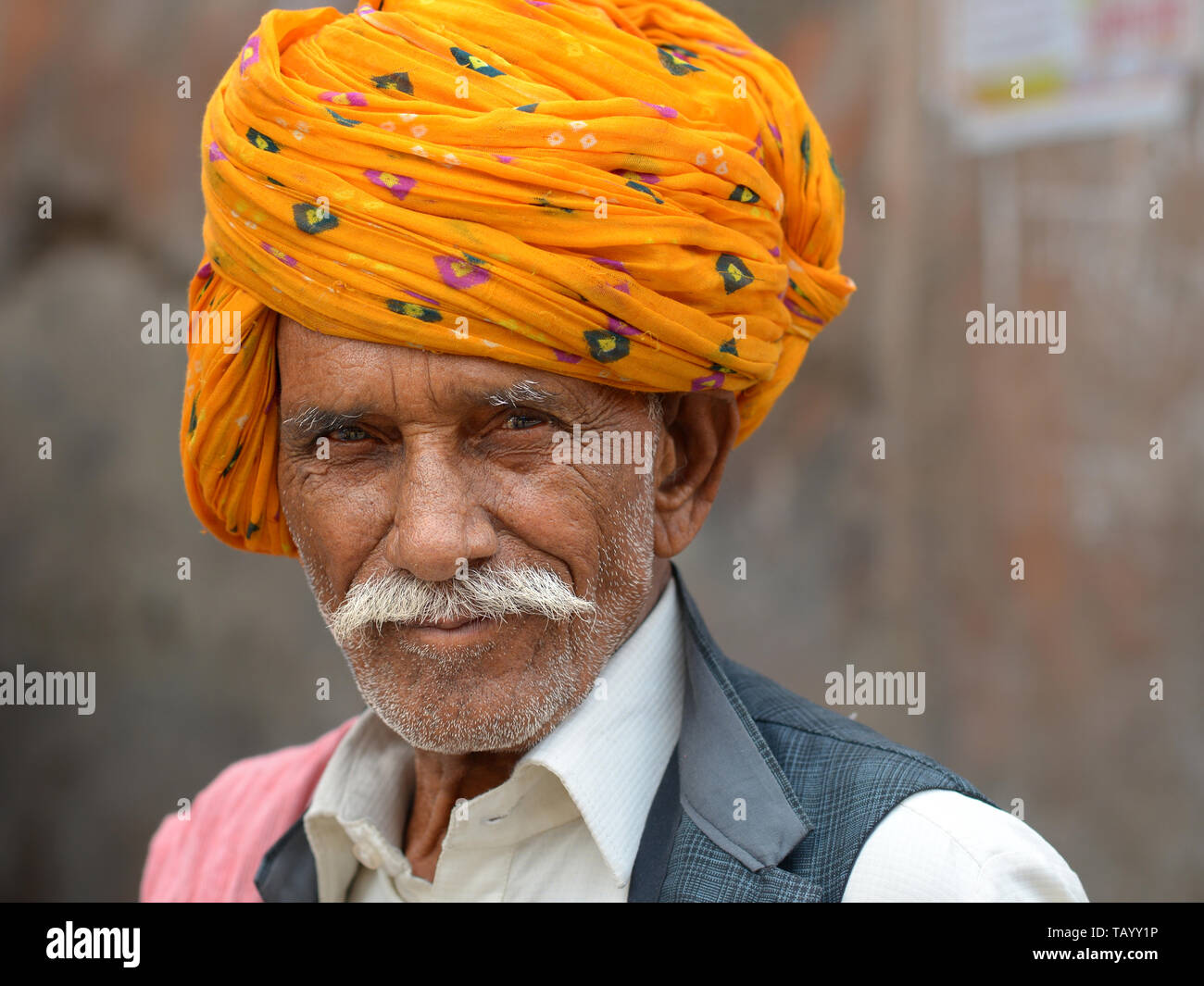 Ältere indische Rajasthani Mann mit einem gelben Rajasthani Turban (pagari) posiert für die Kamera. Stockfoto
